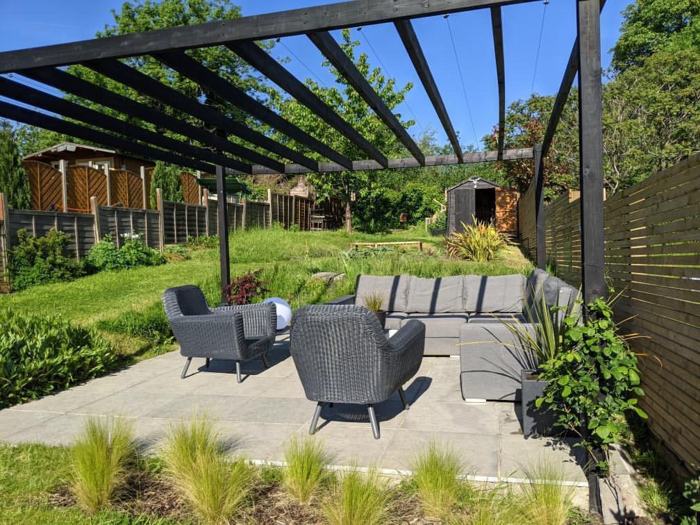 Slatted fencing and black pergola Black modern pergola