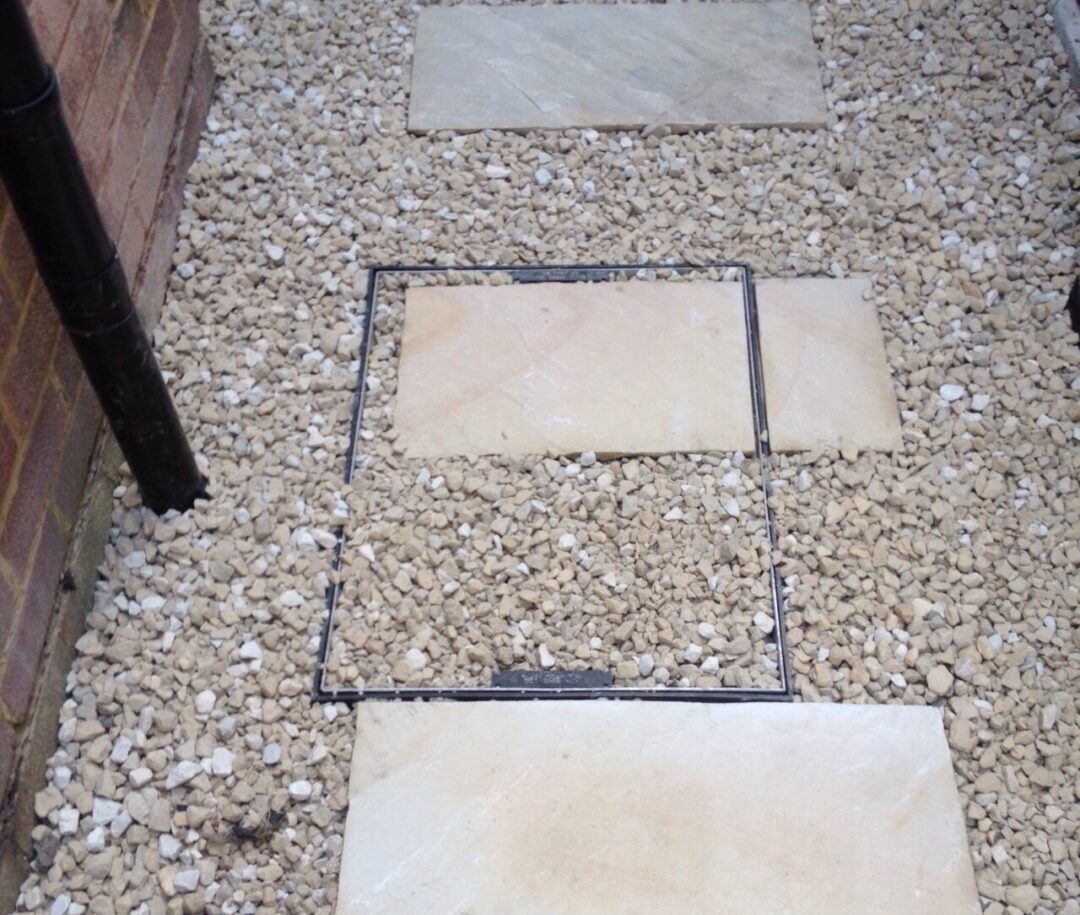 Manhole cover- in gravel and paving Manhole cover- in gravel and paving